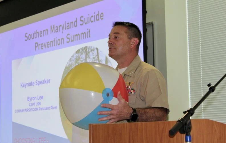 Navy Capt. Byron Lee engages the audience in a game of "bump, bum, catch" before delivering a sobering talk at the Southern Maryland Suicide Prevention Summit.